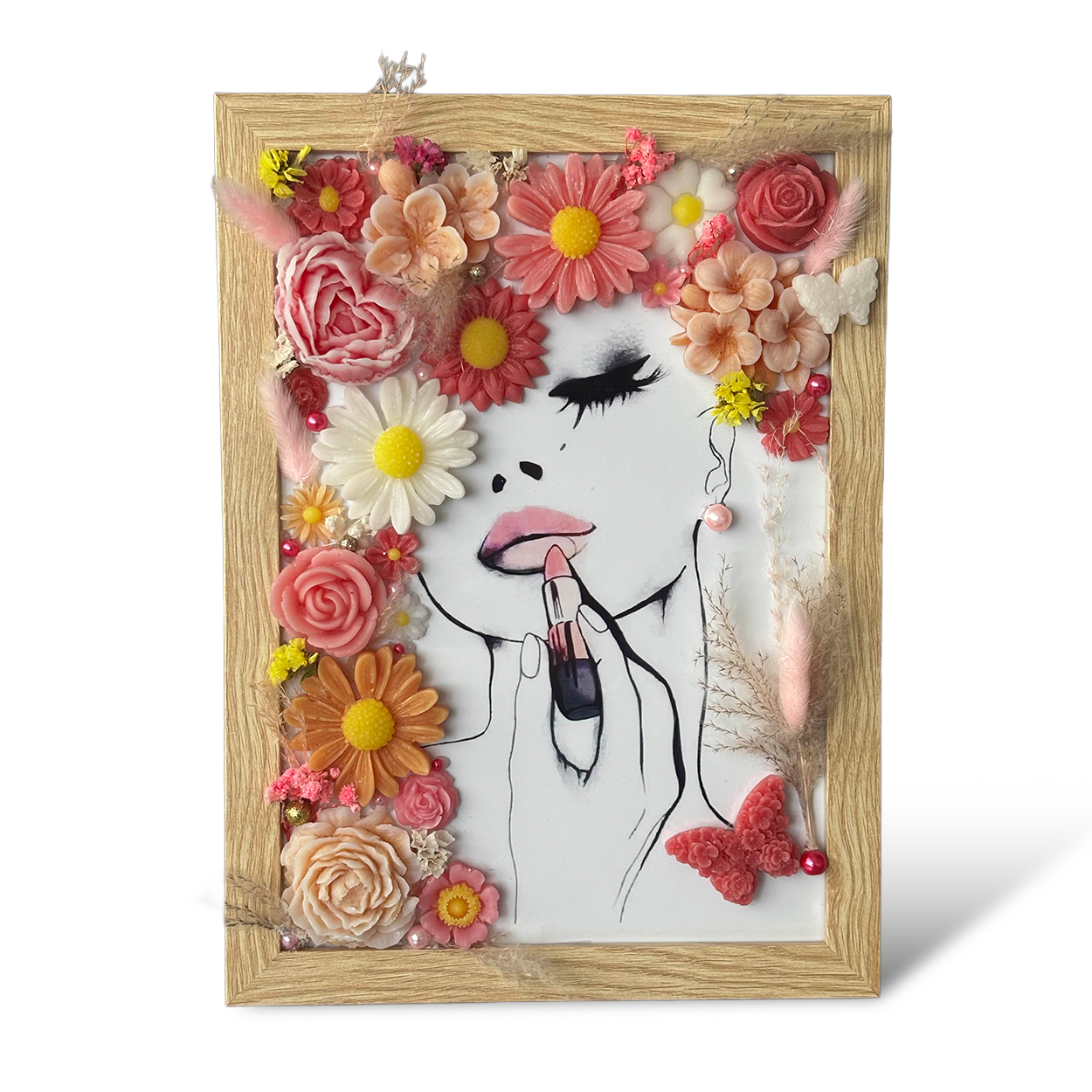 Cadre portrait fleuri personnalisable avec fleurs en cire parfumée – illustration femme appliquant rouge à lèvres, tons corail et rose